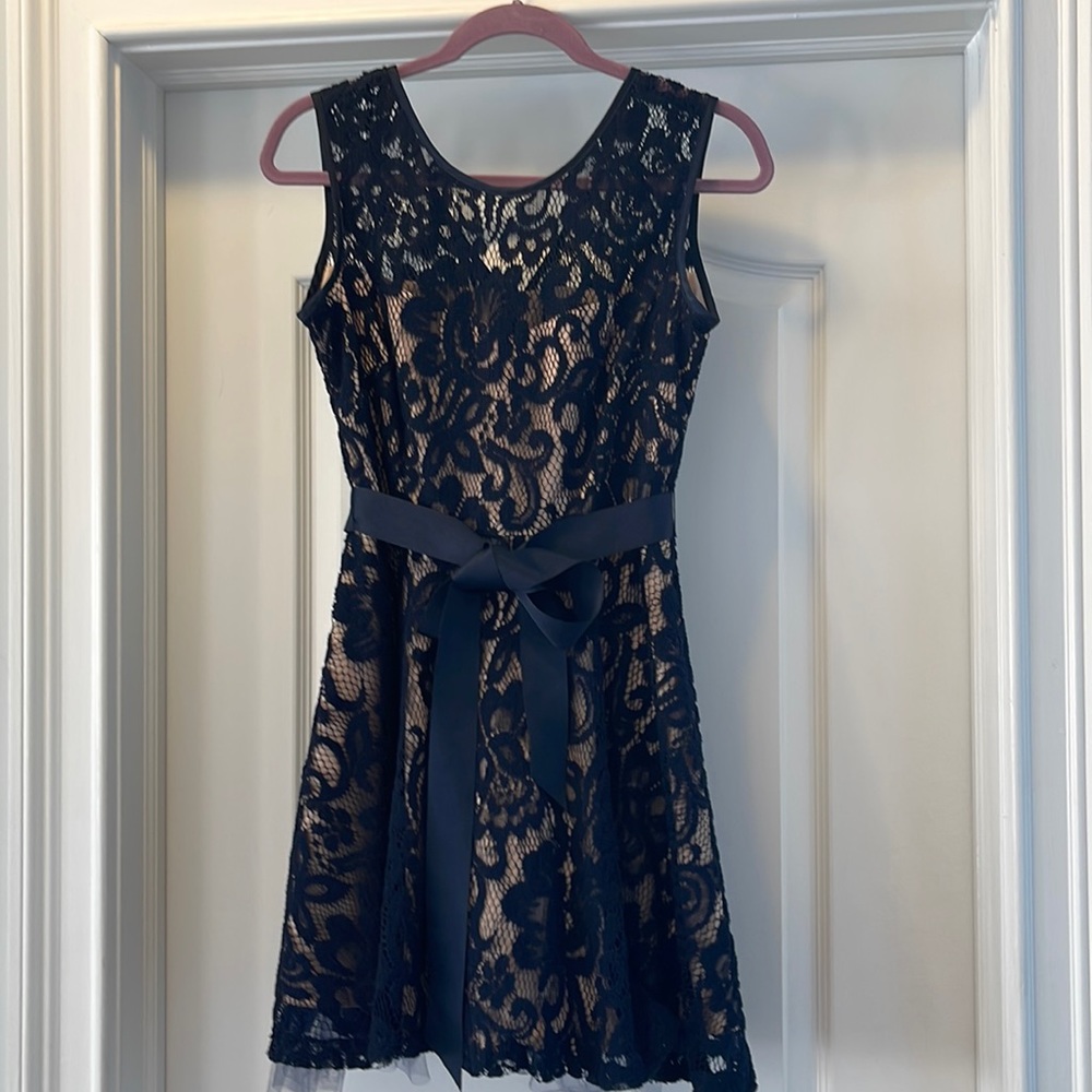 Black lace dress with removable belt and nude underlay.